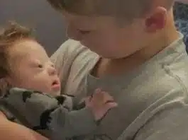 Bebelus cu sindromul Down, tinut in brate de fratele mai mare | Demamici.ro