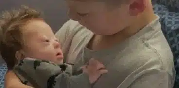 Bebelus cu sindromul Down, tinut in brate de fratele mai mare | Demamici.ro